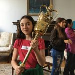A young visitor to Simcoe Hall holds the ceremonial mace in the Chancellor's Office, during Take Our Children to Work Day at U of T