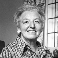 Chancellor Eva MacDonald in a black and white photo, at home wearing a 70s-style patterned collared shirt.