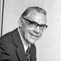 Chancellor Omond Solandt wearing a suit and tie with glasses in a black and white portrait.