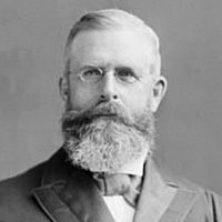 Sir William Mulock wearing glasses and black tie.