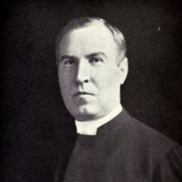 The Honourable and Reverend Henry John Cody in a tab-collared black shirt.
